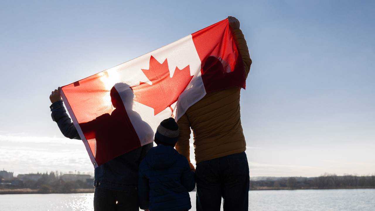 the family holds the Canadian flag behind their backs